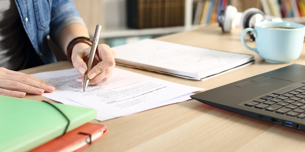 Close Up Of Student Girl Hands Doing Multiple Choice Exam On A desk at home